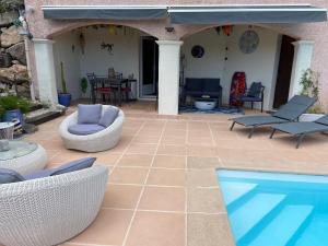 a patio with chairs and a swimming pool at VILLA MARILIS in Montauroux