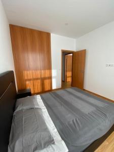 a bedroom with a large bed with wood paneling at Apartamento em braga in Braga