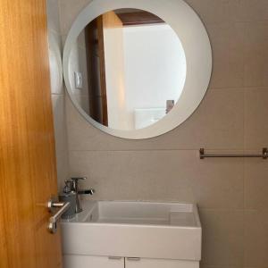 a bathroom with a sink and a mirror at Apartamento em braga in Braga