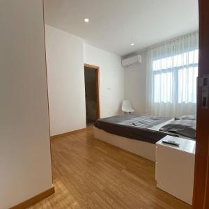 a bedroom with a large bed and a large window at Apartamento em braga in Braga