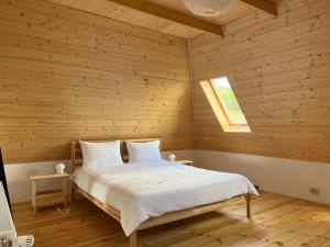 a bedroom with a bed in a wooden room at arra housing near Bistrita in Şintereag +31 photos