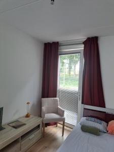 een slaapkamer met een bed, een stoel en een raam bij Dubbelink 3A in Amsterdam