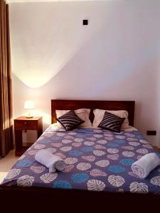 a bedroom with a bed with two towels on it at Villa Avi - Near Airport in Negombo