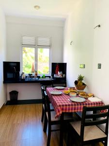 a dining room with a table and chairs and a window at Villa Avi - Near Airport in Negombo