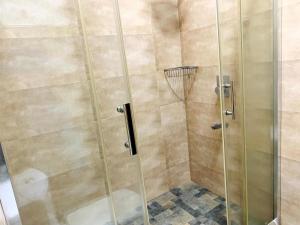 a shower with a glass door in a bathroom at Villa Avi - Near Airport in Negombo