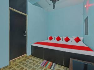um quarto com uma cama com almofadas vermelhas em Flagship Red Rose Hotel & Banquet em Dhanbad