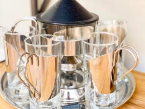 a glass pitcher on a glass tray with four glasses at Lovely studio in Oud-Beijerland in Oud-Beijerland