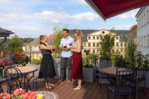 a group of people standing on a deck with drinks at Boutique-Hotel Amalienhof in Weimar