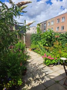 un jardín con plantas y flores frente a los edificios en Dubbelink 3A, en Ámsterdam