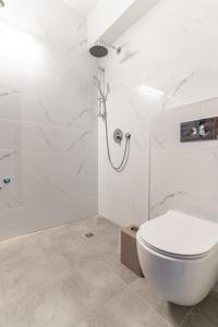 a white bathroom with a toilet and a shower at luxury studio flat in Jerusalem