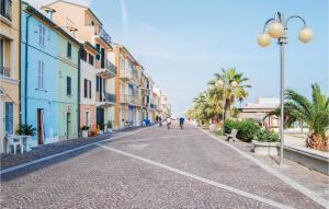 una calle adoquinada con edificios y palmeras en 2 Bedroom Awesome Home In Potenza Picena, en Potenza Picena