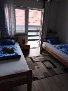 a bedroom with two beds and a window at Apartman Mely in Kulen Vakuf