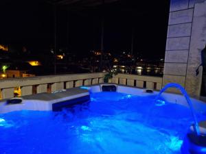 a hot tub on the roof of a building at night at Apartment Mladinić Muse in Pučišća