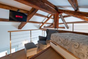1 dormitorio tipo loft con 1 cama y 2 sillas en Loft in Venice - Murano Venier, en Venecia