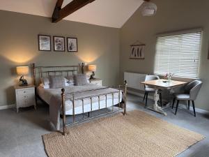 een slaapkamer met een bed, een tafel en een bureau bij White House Farm - Beautiful Self Contained Courtyard Rooms in Whitby