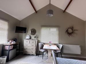 a bedroom with a table and chairs and a dresser at White House Farm - Beautiful Self Contained Courtyard Rooms in Whitby