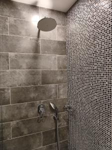 a bathroom with a shower with a tile wall at Orienta Hotel Gyumri in Gyumri
