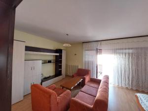a living room with a couch and chairs and a tv at City Park Rooms in Vranje