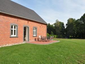 ein Backsteingebäude mit einem Tisch und Stühlen im Hof in der Unterkunft Ferienhaus Spreewaldhof am Wasser "Das Landhaus" in Raddusch