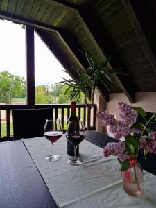 - deux verres de vin assis sur une table avec des fleurs dans l'établissement Ferienwohnung Spreewaldglück, à Burg