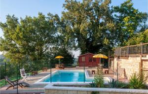 ein Pool mit Sonnenschirmen und ein Haus in der Unterkunft Awesome Home In Morrovalle With Outdoor Swimming Pool in Morrovalle