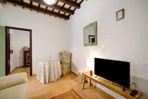 Una sala de estar con un televisor de pantalla plana en una pared. en Casa Pepa Planta Baja, en Chiclana de la Frontera