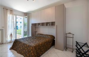 ein Schlafzimmer mit einem Bett in einem Zimmer mit einem Fenster in der Unterkunft Nice Home In Porto Recanati With Wifi And 2 Bedrooms in Porto Recanati