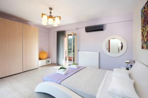 1 dormitorio con 1 cama grande y espejo en Contemporary Corfu Retreat - 3 Bedrooms - Villa Girasole - Artful Decor - Lush Garden - Tranquil Setting en Dafnila