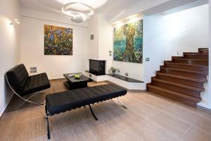 una sala de estar con 2 sillas y una pintura en la pared en Contemporary Corfu Retreat - 3 Bedrooms - Villa Girasole - Artful Decor - Lush Garden - Tranquil Setting, en Dafnila