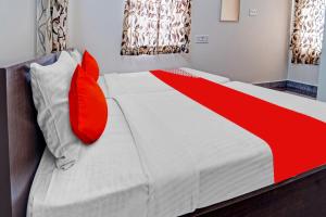 a bedroom with a bed with red pillows at Super OYO Flagship Royal Residency in Nāmakkal