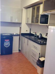 a small kitchen with a sink and a microwave at Port Golf Marina Families Only in El Alamein