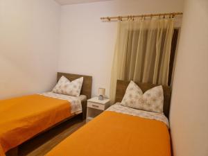 a bedroom with two beds and a window at Apartment Mladinić Muse in Pučišća +19 photos