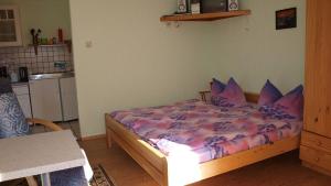 een slaapkamer met een bed met paarse lakens en kussens bij Ferienwohnungen Klinkmüller in Fleißdorf