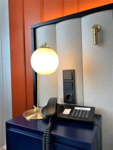un téléphone assis sur un bureau à côté d'un téléphone dans l'établissement voco Dusseldorf Seestern, an IHG Hotel, à Düsseldorf