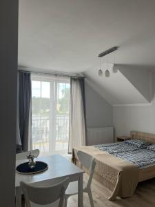 Un dormitorio con una cama y una mesa y una ventana. en Lawendowe domki, en Karwia 63 fotos más