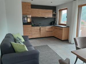 uma sala de estar com um sofá e uma cozinha em Innerpasthof 
