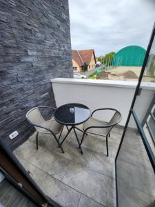 2 sillas y una mesa en el balcón en Armins's Residence 2 - Villa en Dumbrăviţa