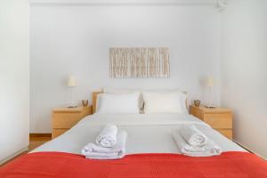 1 dormitorio con 1 cama con toallas en The HostMaster Luminous Elite Estate en Athens