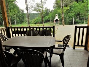 a table and chairs on a patio with a grill at Gite les Acacias - les gites des hauts de vialot in Auriac-du-Périgord