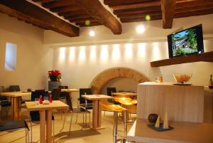 un ristorante con tavoli, sedie e un camino di Coldimolino Resort a Gubbio