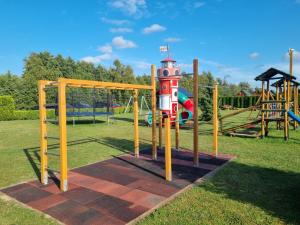 a playground in a park with a playground at Domki Letniskowe Krakus in Rusinowo