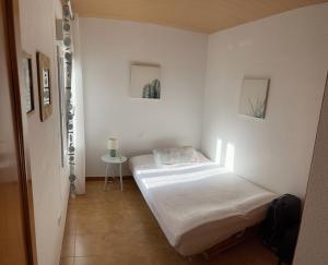a small white room with a bed and a table at CHALET INDEPENDIENTE COn VISTAS AL MAR in Peniscola