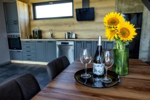 a table with two wine glasses and a vase of sunflowers at SM VIP HOUSES in Shanovo