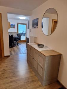 een woonkamer met een aanrecht en een spiegel bij Appartement Ebster in Pettneu am Arlberg