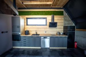 a kitchen with blue cabinets and a sink and a window at SM VIP HOUSES in Shanovo