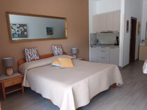 a bedroom with a large bed and a kitchen at Apartments Fina in Crikvenica