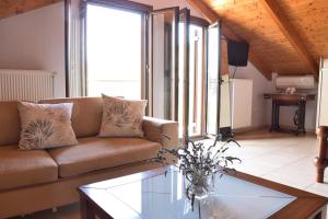 a living room with a couch and a glass table at Villa Andrew in Áyioi Saránda