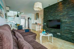 uma sala de estar com um sofá castanho e uma parede de tijolos em Villa Luisa Seaview 3 Casasol em Torrox Costa