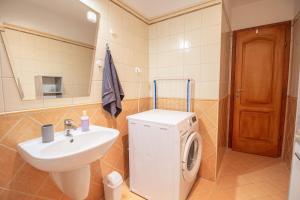 a bathroom with a sink and a washing machine at Viky's Apartment in Győr