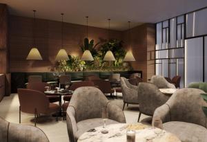 een restaurant met tafels, stoelen en planten bij Istanbul Marriott Hotel Pendik in Istanbul